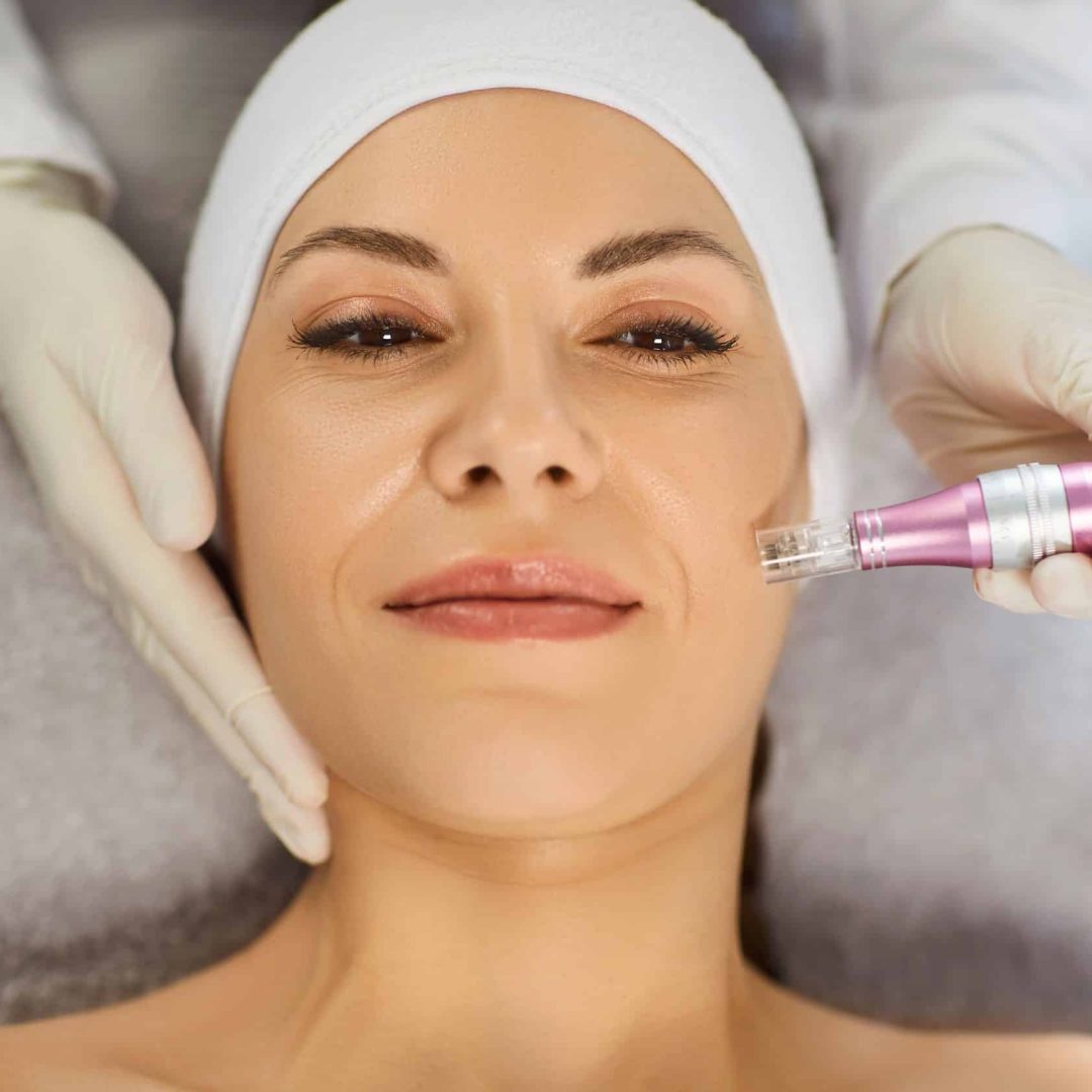 Cosmetologist, dermatologist beautician procedure, female face microneedling using dermapen Cosmetologist, dermatologist beautician procedure, female face microneedling using dermapen for skin care, facial deep cleansing, skincare instrument professional treatments, happy woman enjoying