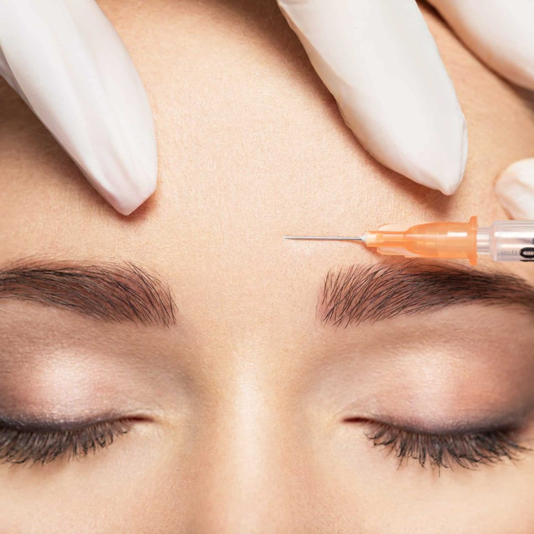 Woman getting cosmetic injection of botox near eyes Woman getting cosmetic injection of botox near eyes, closup. Woman in beauty salon. plastic surgery clinic.
